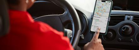 Femme au volant qui regarde son téléphone accroché à la ventilation