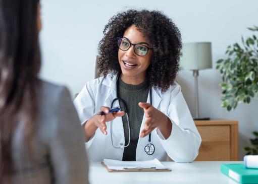Une médecin expliquant avec ses mains à une patiente